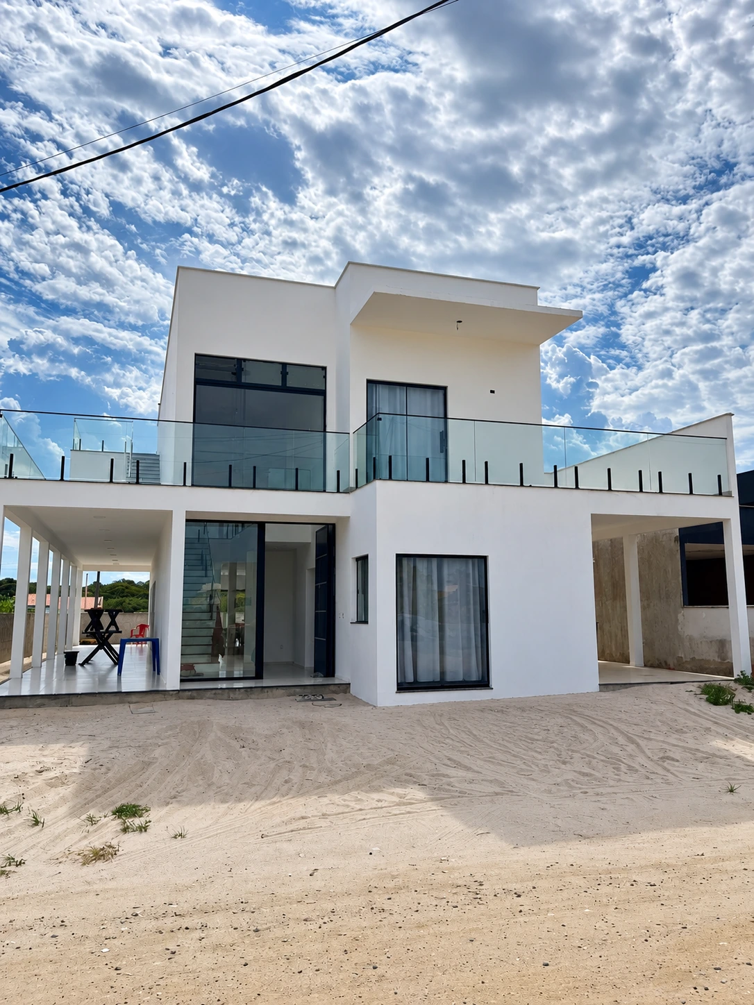 Fachada da Casa Branca: dois pavimentos brancos, varanda coberta por colunas e terraço superior com guarda-corpo de vidro