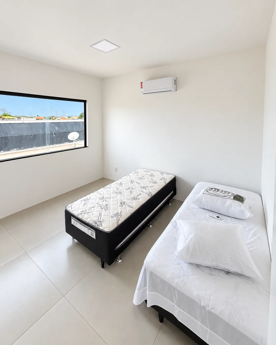 Quarto da Casa Branca com duas camas de solteiro e janela horizontal